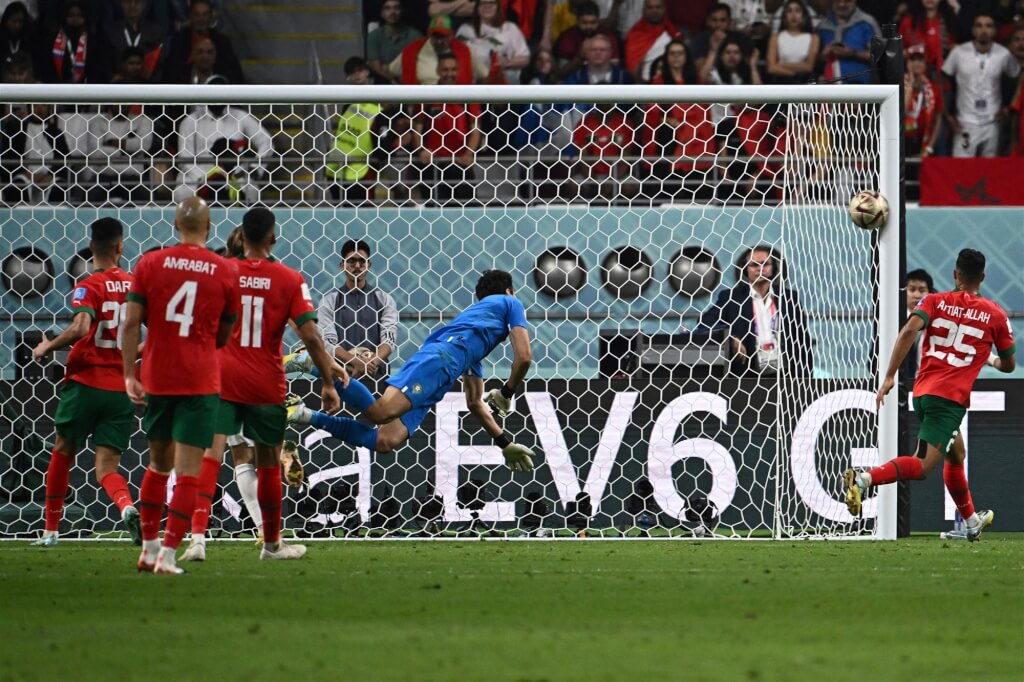 克罗地亚12月18日在世界杯季军赛对决摩洛哥，前锋奥尔西奇在左路看似传中，球却巧妙越过摩洛哥门将博努（蓝衣者）后撞到门柱反弹入门，这记绝妙进球成为致胜球。