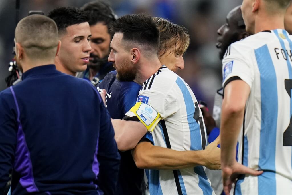 克罗地亚在准决赛败给阿根廷，赛后克罗地亚队长、37岁老将“魔笛”莫德里奇（中间蓝衣者）与阿根廷队队长梅西（中间白衣者）拥抱。